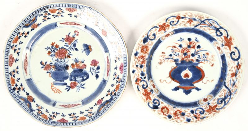 Een paar Imari borden in Chinees porselein met bloemenvazen in het decor. Haarlijntje.
