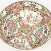 Een coupe van Chinees Canton porselein met een famille rose decor van pioenen en personages in interieurs in uitsparingen. Onderaan gemerkt en op houten sokkeltje.