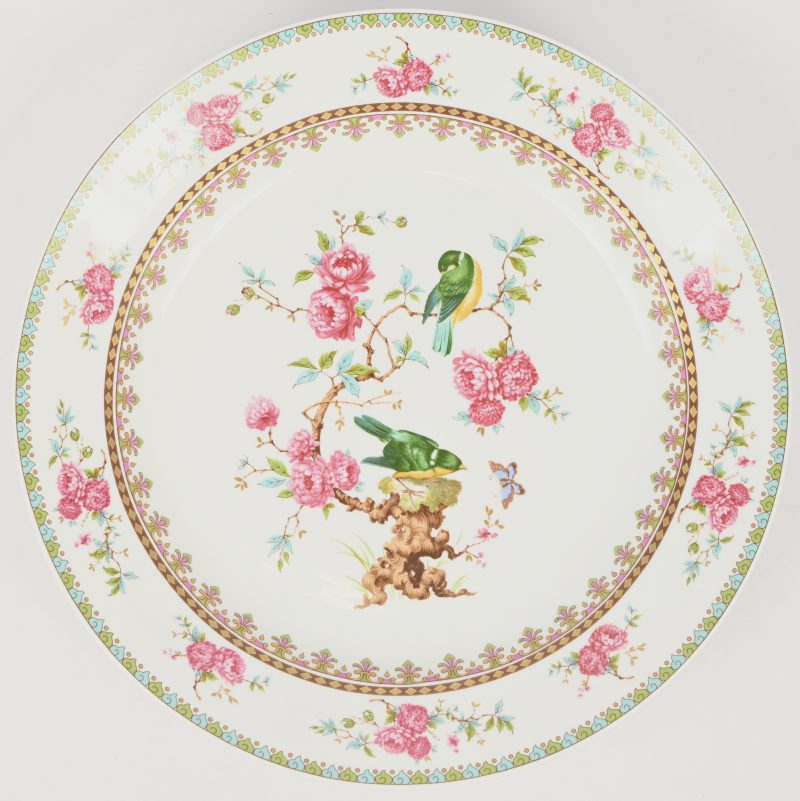 Een grote schotel van veelkleurig porselein met een decor geïnspireerd op de famille rose met vinken op het plat en rozen op de vleugel. Onderaan gemerkt.