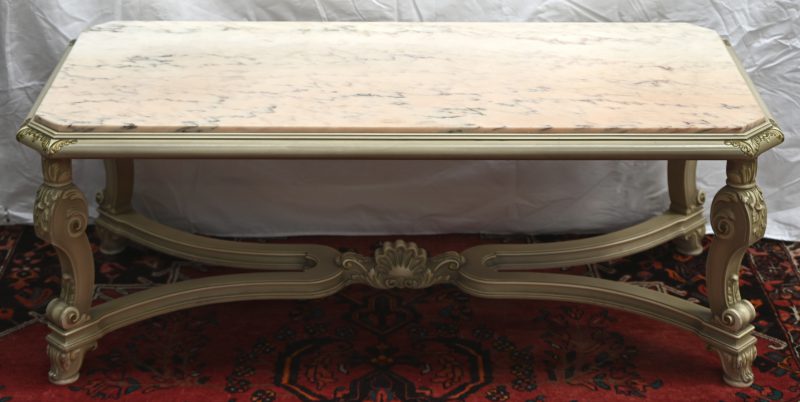 Een rechthoekige salontafel van crèmekleurig hout in Lodewijk XIV-stijl. Met gevlamd witmarmeren blad.