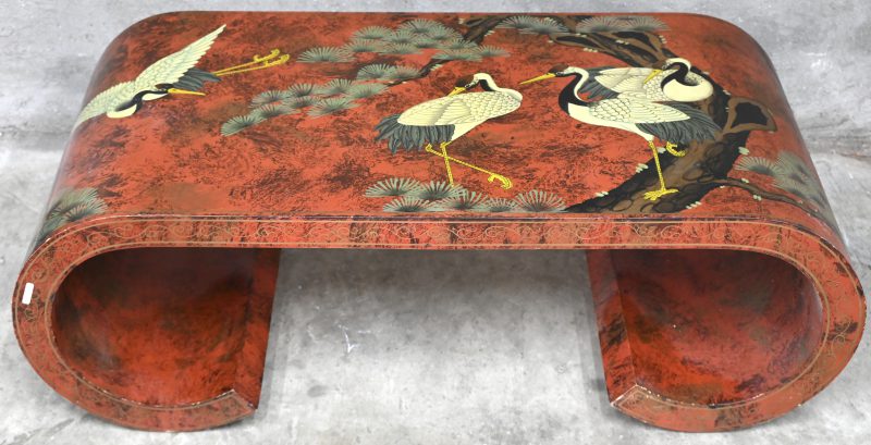 Een salontafel versierd in Chinese lak met reigers bij een vijver op rode fond. Poten in een doorlopende krul. Lichte slijtage.