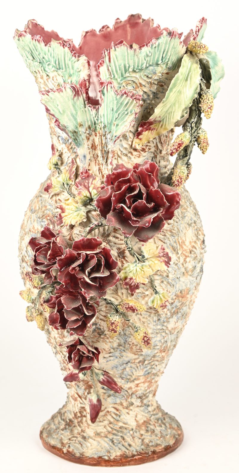 Een vaas in meerkleurig barbotine aardewerk, floraal organische decoratie met meerdere kleine beschadigingen.