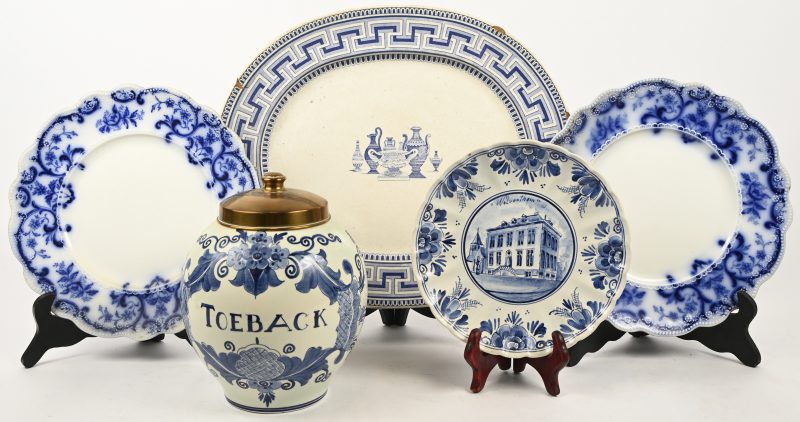 Een gevarieerd lot blauw-wit aardewerk en porselein bestaande uit een grote schaal met schilferschade, 3 borden en een tabakspot.