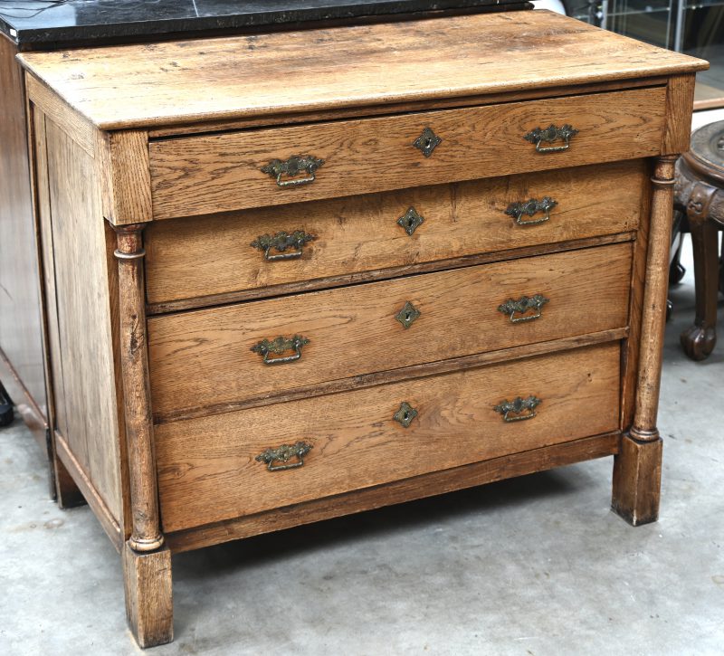 Antieke massief houten commode met koperen beslag, vier laden. Het front is geflankeerd door twee zuilen.