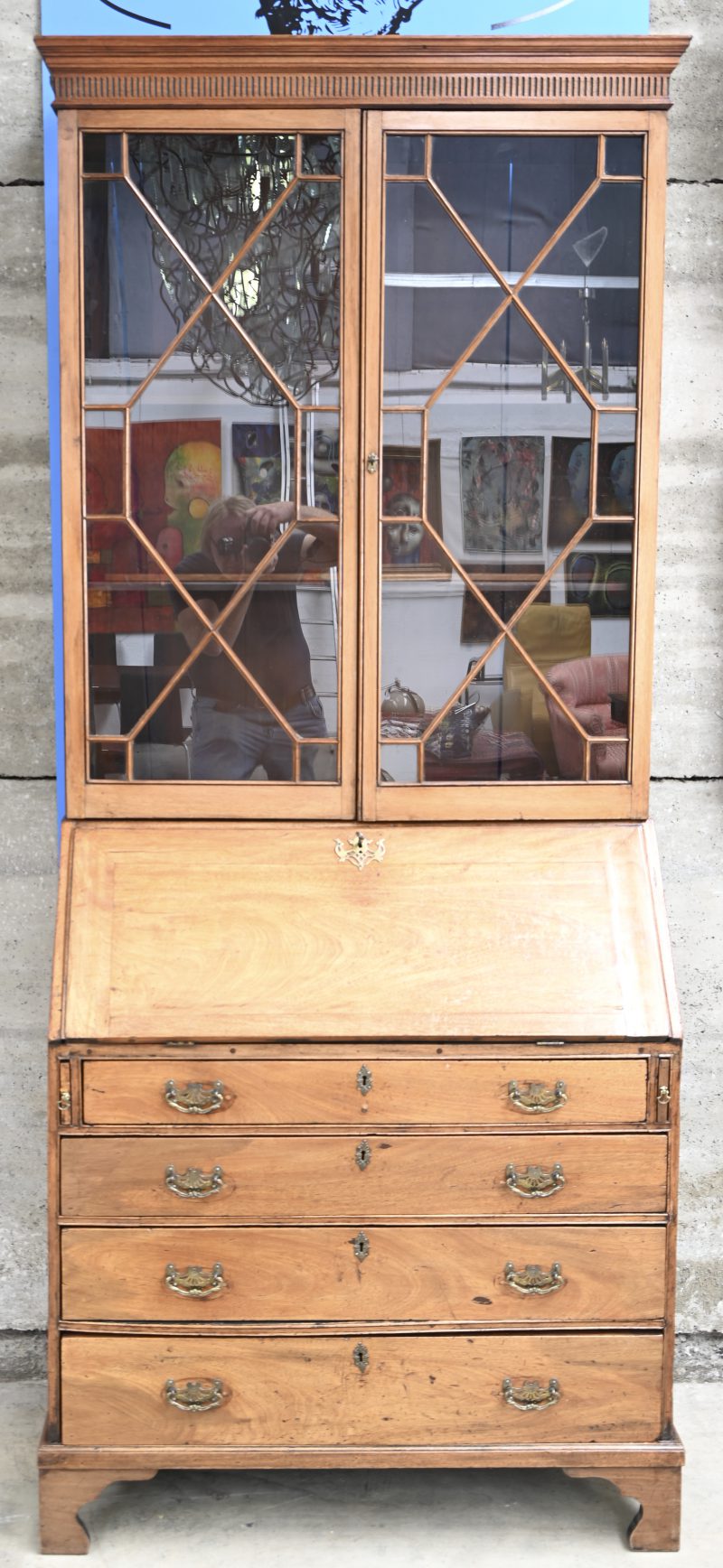 Antieke secretaire met vitrine. Onderaan vier laden met messingen handvatten.