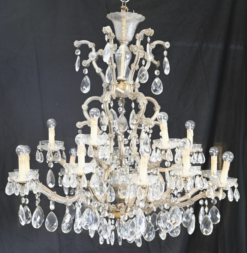 Een imposante luchter van kristal, glas en messing met zestien lichtpunten. Met talrijke geslepen pendeloques. Régencestijl.