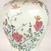 Een tafellamp met als voet een Chinese dekselvaas met het decor van bloeiende struiken en vlinders.