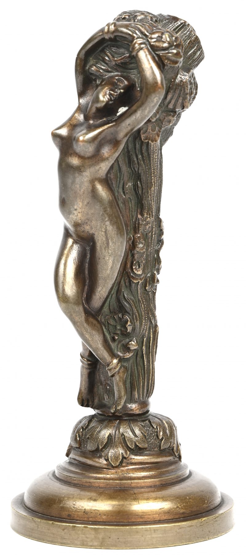 Een bronzen beeldje van een naakte dame gekneveld aan een boomstronk.