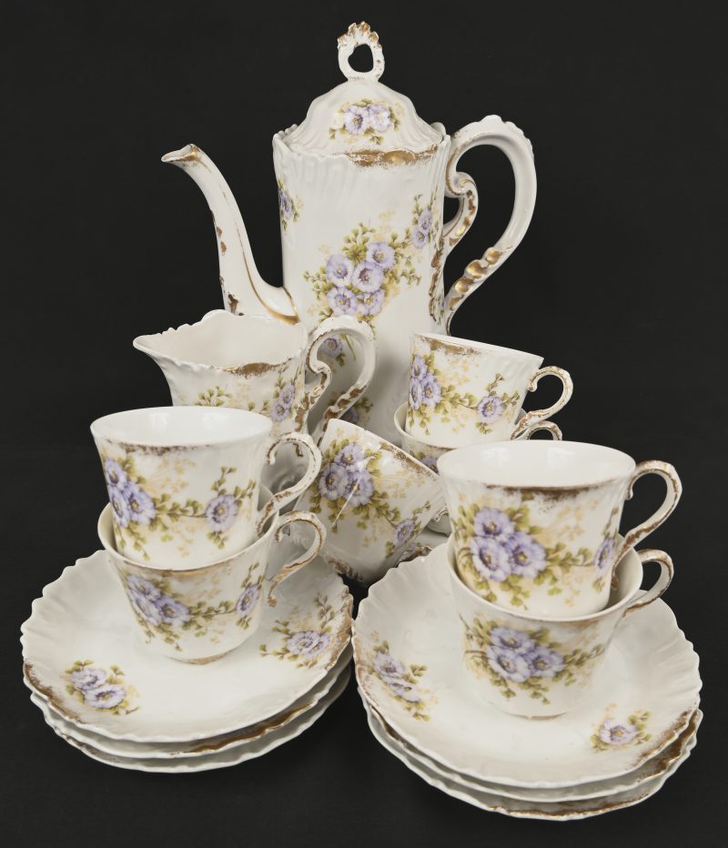 Een antiek porseleinen theeserviesje met handbeschilderd floraal decor, gemerkt Limoges France. Bestaande uit een theepot, een melkkannetje, 7 tassen en 7 ondertassen.