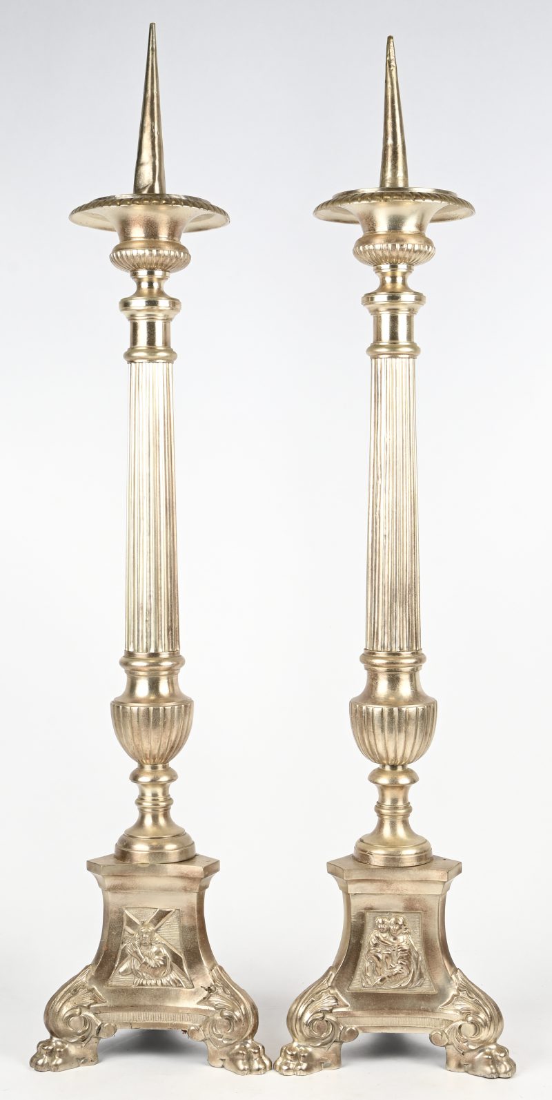 Een set van 2 grote metalen kandelaars met religieus thema.