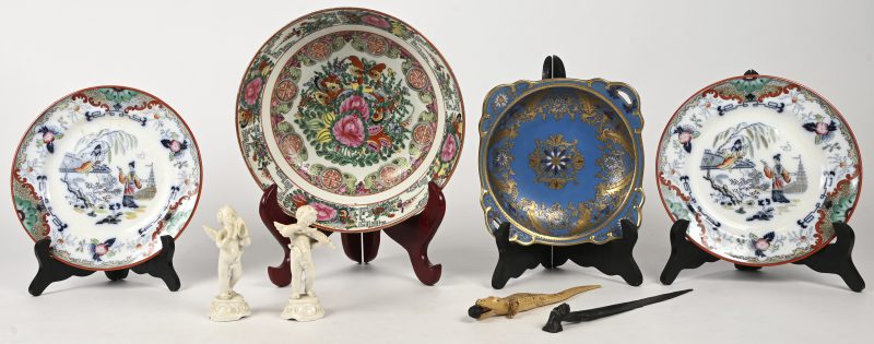 Een gevarieerd lot waaronder porselein en aardewerk bestaande uit 2 borden, P. Regout waarvan 1 gerestaureerd, een grote kom naar Chinees voorbeeld en een blauw schaaltje met vergulde decoratie, toegevoegd 2 engeltjes waarvan één gelijmd en 2 Afrikaanse briefopeners in hout en kunststof.