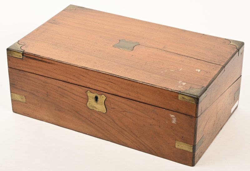 Een antieke houten reissecretaire met elementen in messing.