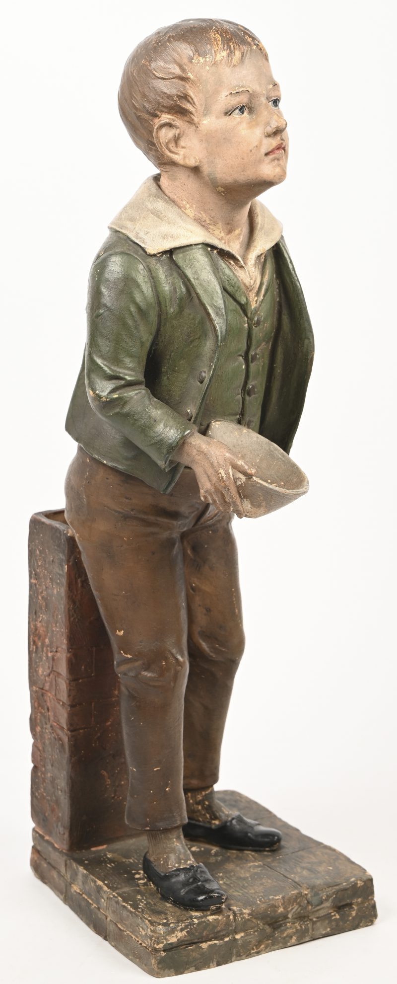 Een aardewerken beeld van een bedelende jongen met één hand. Circa 1900.