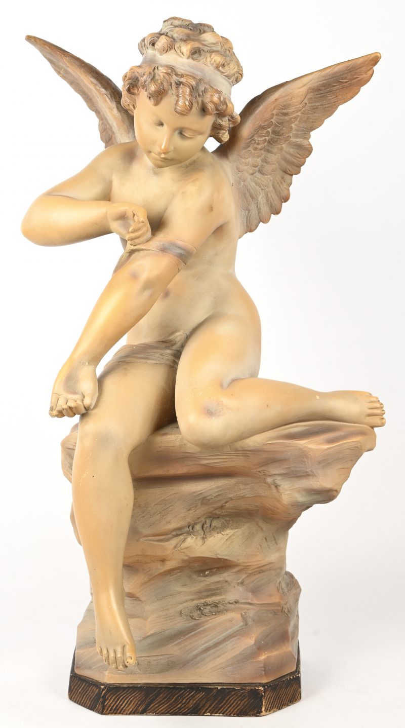 “Amor”, een terracotta beeld, gesigneerd R. Aurili. Topje van een pink manco.