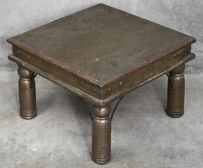 Een massief houten koloniale salontafel met koperen beslag.