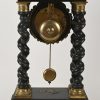 Een schouwpendule, hout en koper.