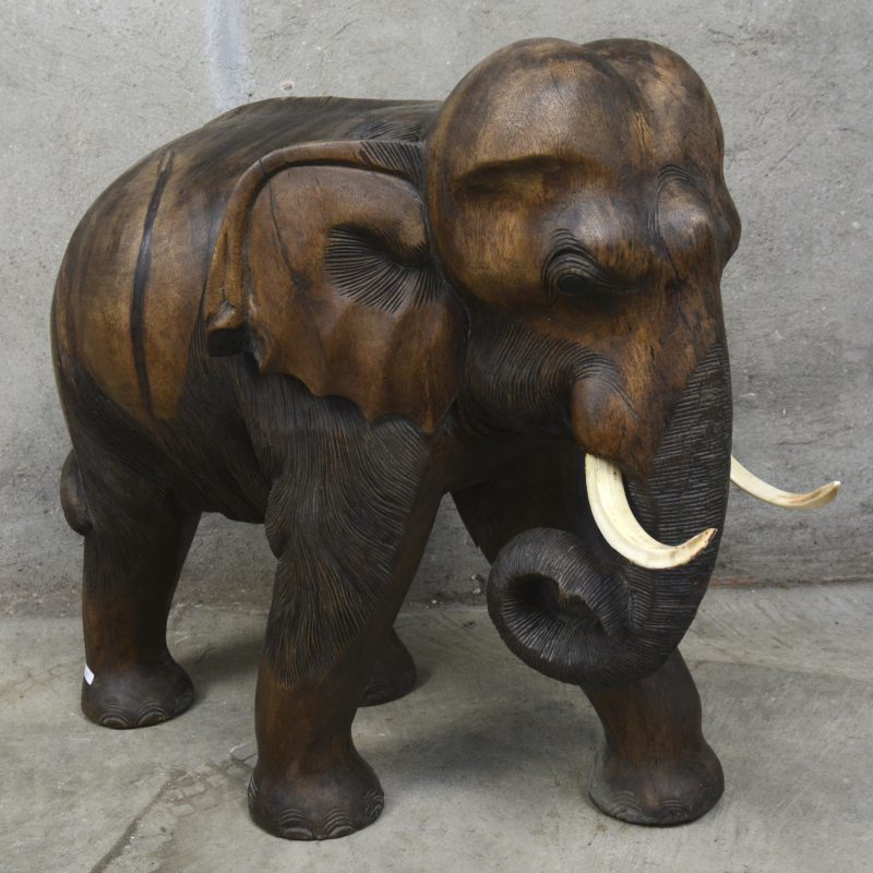 Een massief houten gesculpteerde olifant met everzwijntanden.
