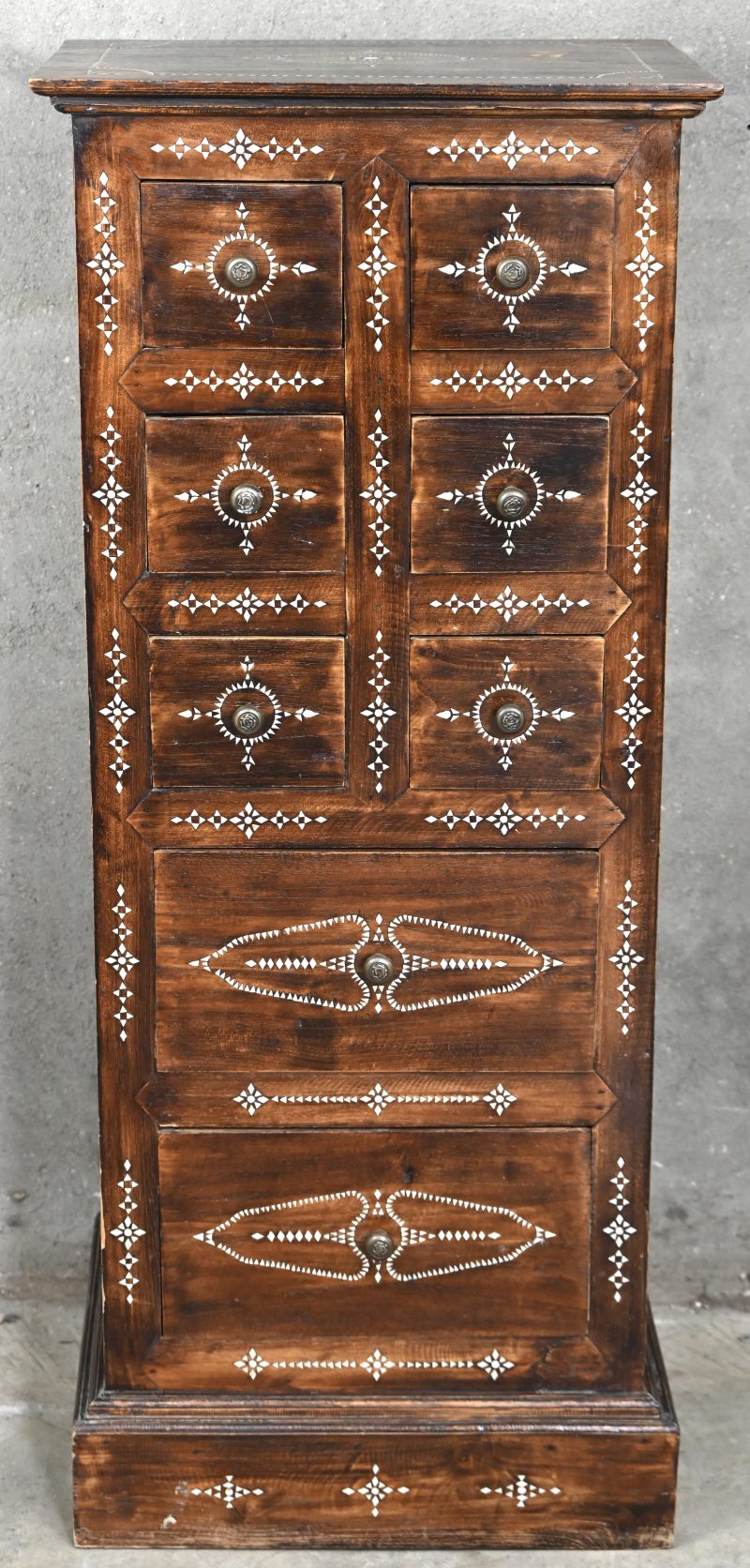Een halfhoge ladenkast met inlegwerk van parelmoer. Zes kleine en twee grote laden.