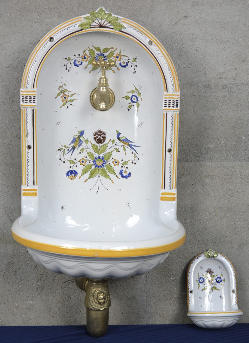 Een wasbekken van geglazuurd aardewerk voor wandmontage. Met messing kraan en bijpassend zeepbakje. Getekend Maurice Herbeau, Lille.