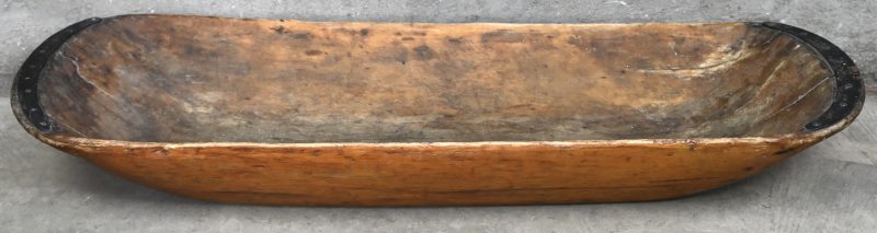 Een antieke houten deegtrog, met ijzeren beslag.