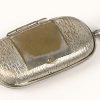 Een zilveren borrelglaasje en een lot verzilverd metalen snuisterijen bestaande uit 2 miniatuur potjes, een antieke muntenhouder, een pince-nez en een drukkersloupe.