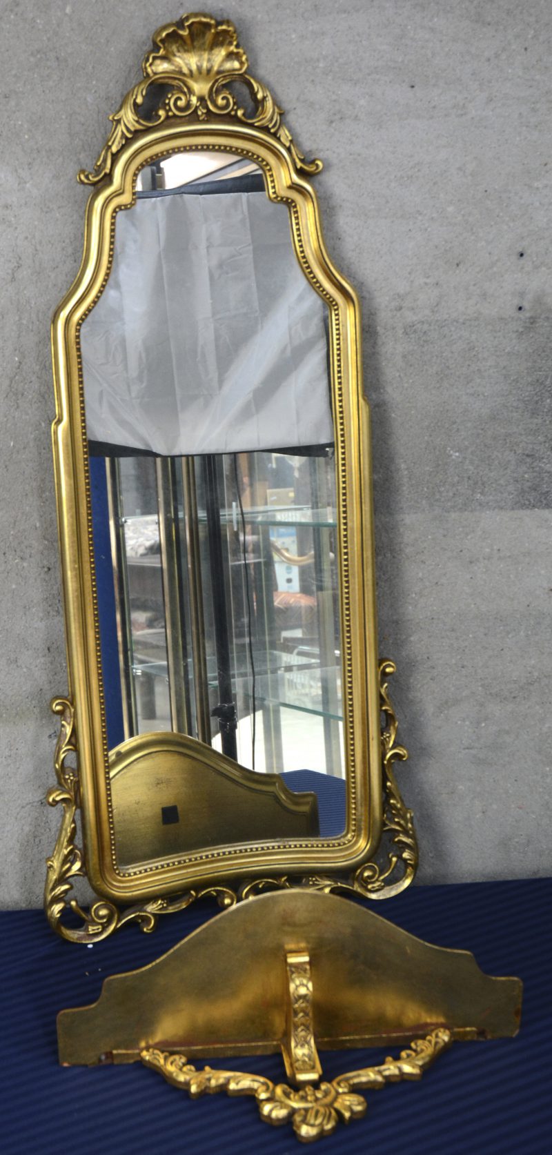 Een spiegel in vergulde kader met bijbehorende console.