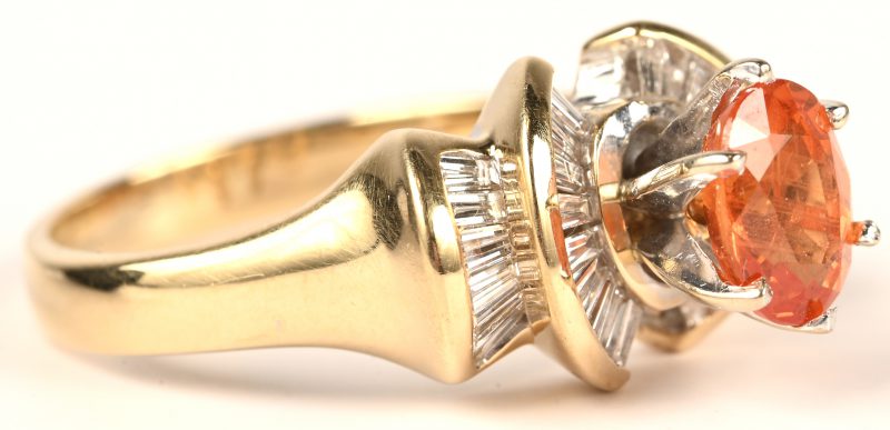 Een 14 kt wit en geelgouden ring bezet met diamant baguetten met een gezamenlijk gewicht van 1,08 ct. en een Brasiliaanse naranja saffier van 1,64 ct. Met certificaat.