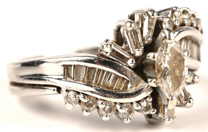 Een 14 kt witgouden ring bezet met briljanten een  diamant in markies geslepen en baguetten met een gezamenlijk gewicht van 1,08 ct. VS SI. Met certificaat.