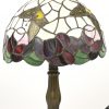 Een tafellampje met kap in Tiffany stijl, met een bronzen voet. Met gele vlinders in het decor.