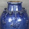 Een Chinese blauw geglazuurde aardewerken Martaban vaas op metalen staander.