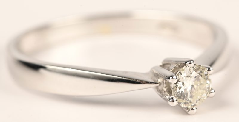 Een 18 kt witgouden ring bezet met een solitair van 0,18 ct. GSI.