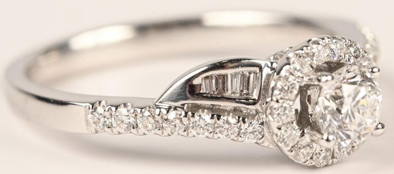 Een 18 kt witgouden ring bezet met een centrale briljant van 0,32 ct. En baguetten met een gezamenlijk gewicht van 0,35 ct.