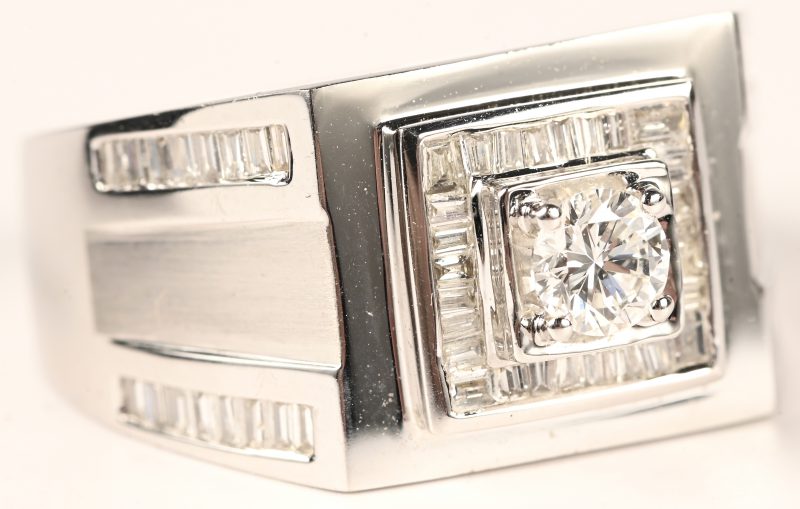 Een 18 kt witgouden herenring bezet met een centrale briljant en briljanten en baguetten met een gezamenlijk gewicht van totaal 1,63 ct.