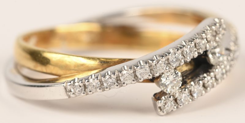 Een 18 kt wit- en geelgouden ring bezet briljanten met een gezamenlijk gewicht van 0,45 ct.