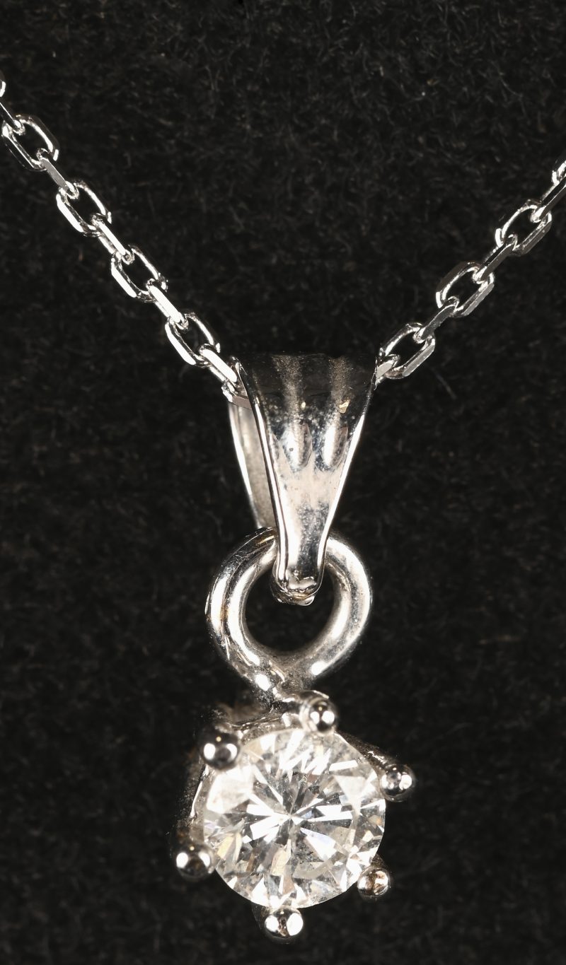 Een 18 kt witgouden ketting met hanger met een centrale briljant van 0,31 ct. FSI1.