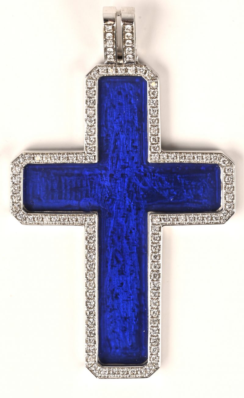Een 18 kt witgouden hanger met een crucifix van blauw email en briljanten met een gezamenlijk gewicht van 1,02 ct.