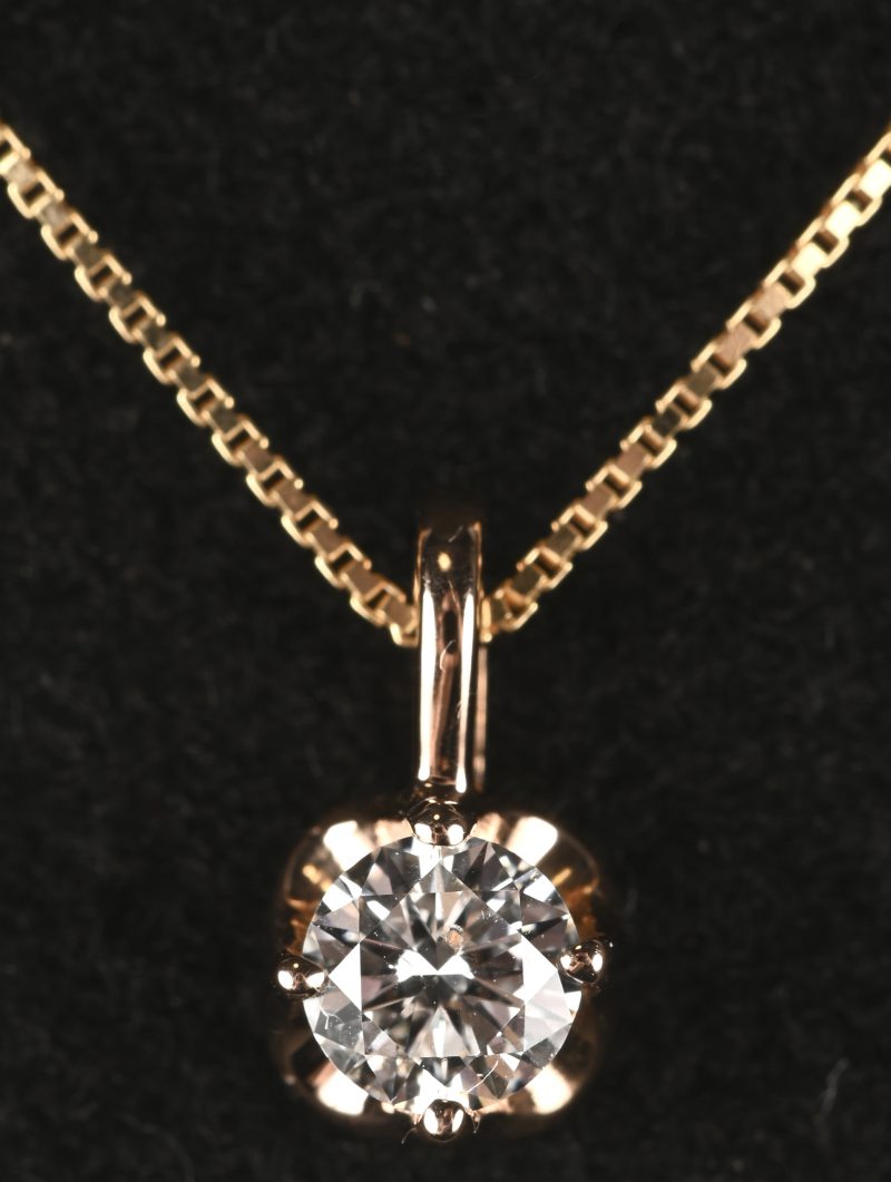 Een 18 kt geelgouden ketting met hanger met een centrale briljant van 0,30 ct. FVI1.