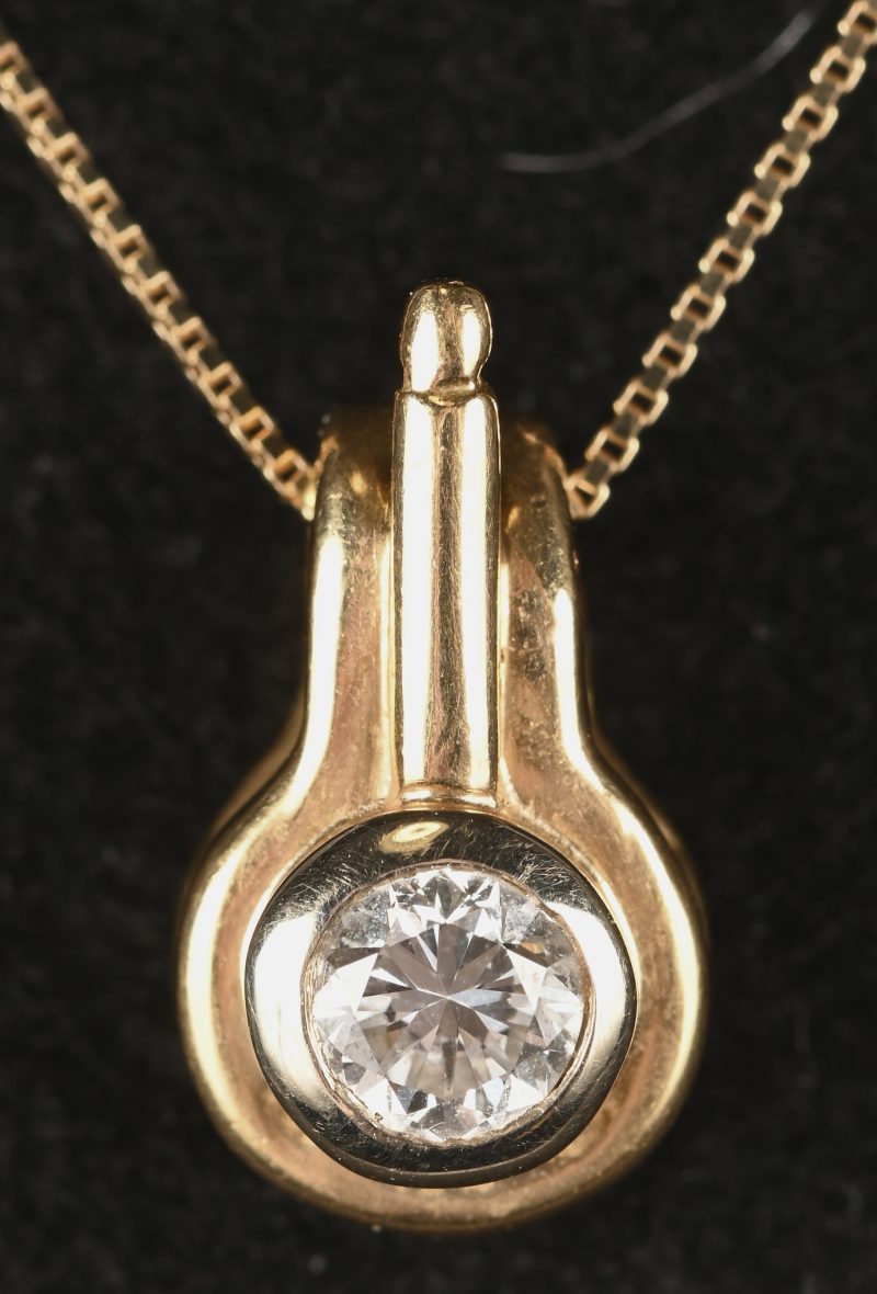 Een 18 kt geelgouden ketting met hanger met een centrale briljant van 0,29 ct. FVS1.