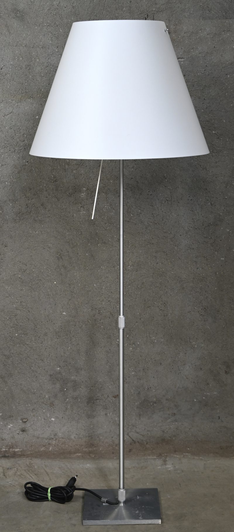 Een Italiaanse design lamp met in hoogte verstelbare aluminium voet, model Costanza. In werkende staat. Met witte kap.