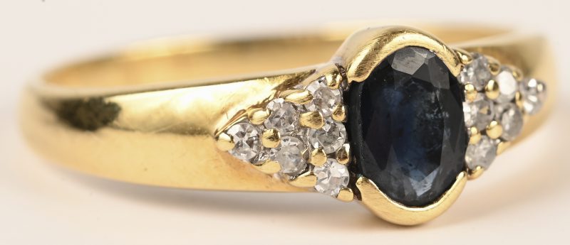 Een 18 kt geelgouden ring bezet met 2 kleine briljantjes en een saffi van +- 0,30 ct.