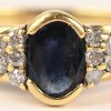 Een 18 kt geelgouden ring bezet met 2 kleine briljantjes en een saffi van +- 0,30 ct.