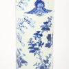 Een bekervaas in Chinees blauw-wit met fauna en flora in het decor. Haarlijn.
