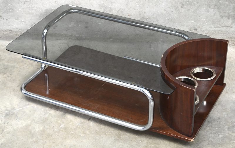 Een salontafel in art-deco stijl. Met houten basis, verchroomde buizen en een glazen blad. De open kant heeft drie open voeten voor flessen.
