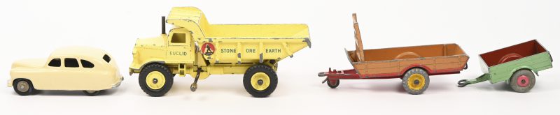 Een lot van vier oude Dinky Toys voertuigen en aanhangers. Farmtrailer nr. 27B, aanhangwagen nr. 341, Euclid rear dump truck nr. 965 en een herschilderde Vanguard personenwagen.