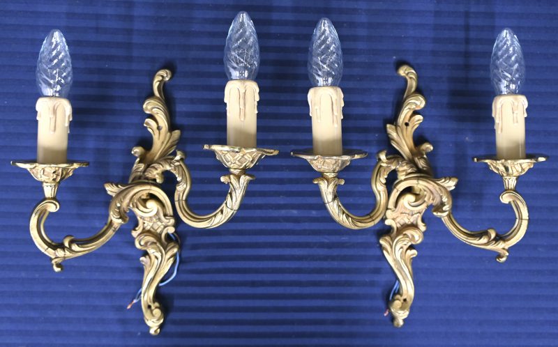 Een paar bronzen wandlampen in barokke stijl.