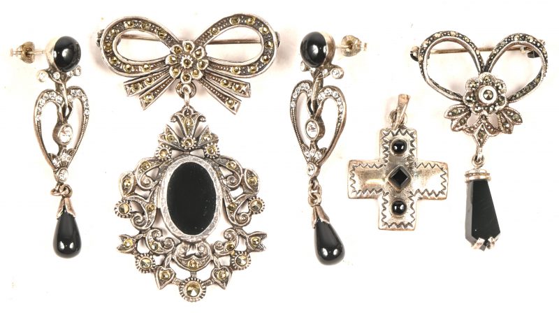 Een paar oorbellen, een broches en een hanger van zilver bezet met markasiet en onyx.