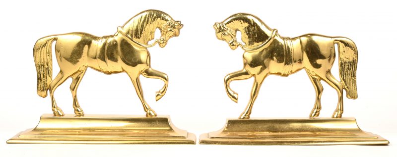 Een set messing haardijzers in de vorm van een paard.