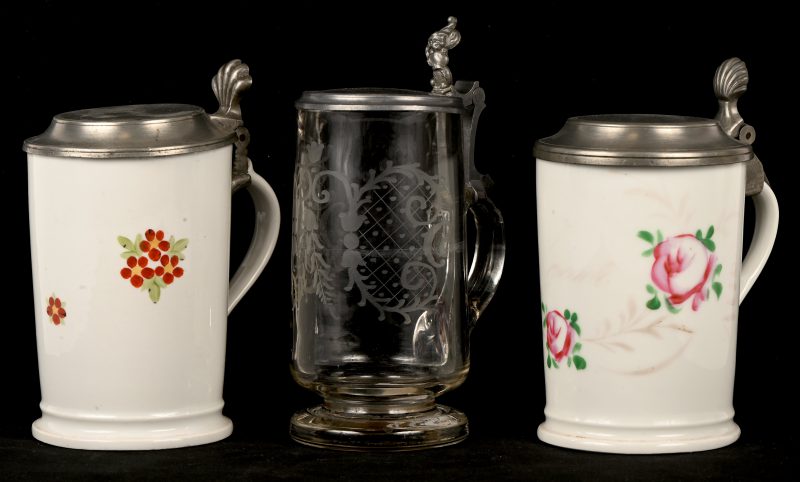 Een lot van drie bierkruiken met deksel. 2 x beschilderd porselein en 1 x glas met geslepen decoratie.