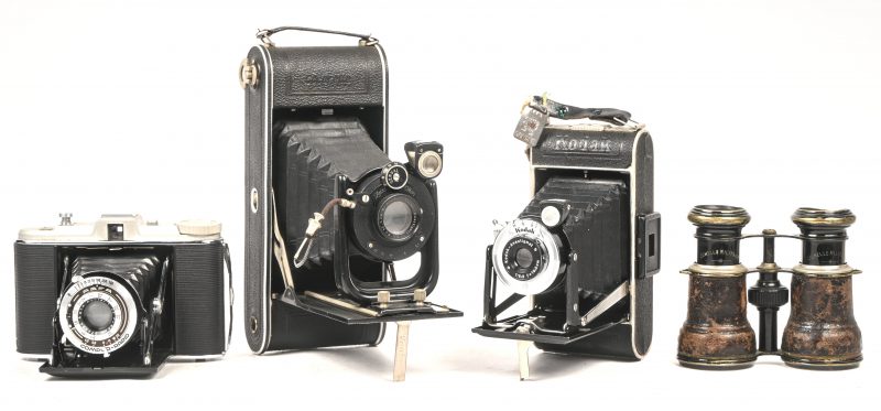 Een lot van 3 vintage balgcamera’s bestaande uit een Kodak Junior 620, een Zeiss Ikon Cocarette 514/15 en een Agfa Isolette. Toegevoegd een antieke verrekijker gemerkt Jumelle Militaire.