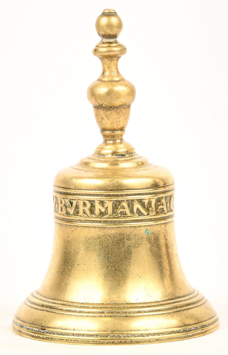 Een bronzen handbel in de vorm van een kerkklok.